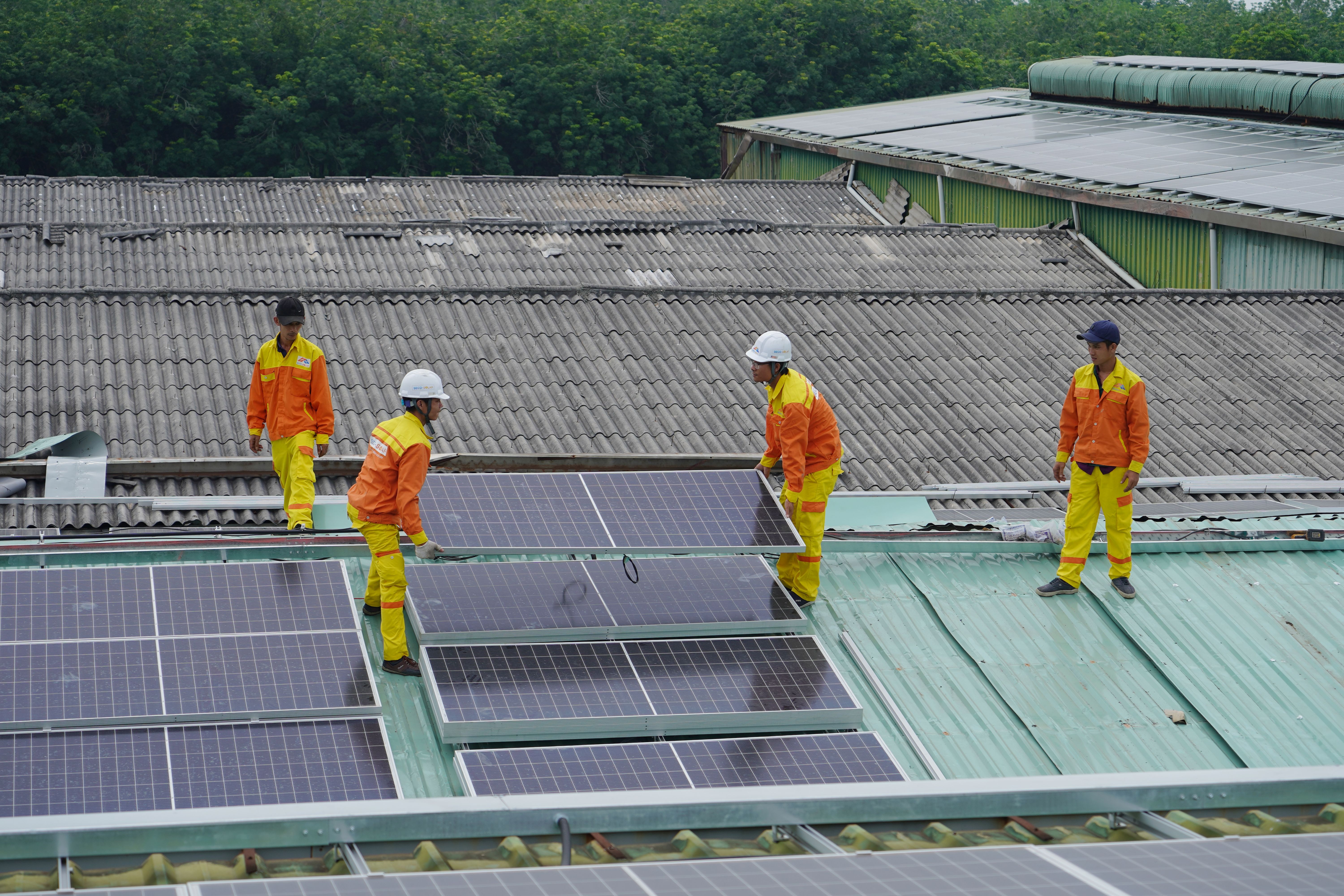 Technicians installing rooftop solar panels