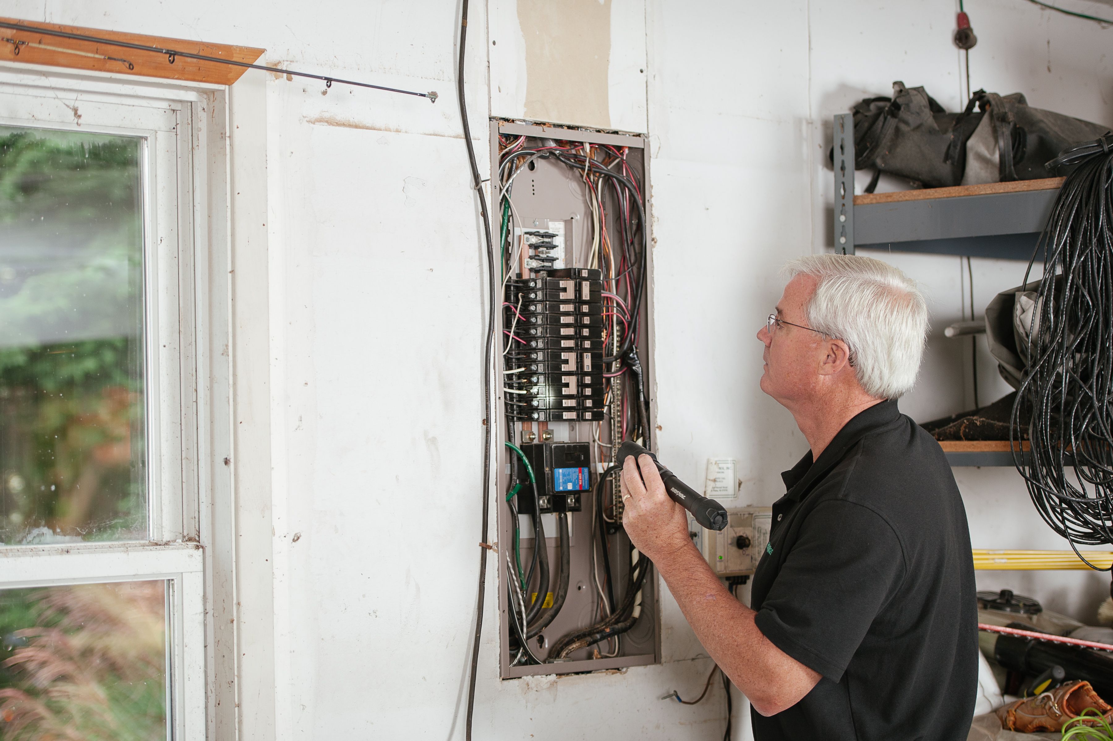 Electrician inspecting a residential breaker panel